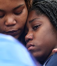 Shaniqua Allen embraces her 14-year-old daughter, Ni’Aveya Allen, during a prayer vigil Feb. 8 for Mrs. Allen’s 3-year-old son, Sharmar L. Hill Jr., who was shot and killed by gunfire while playing outside the family’s home in the Hillside Court public housing community on Feb. 1.