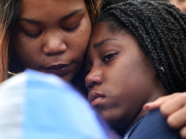 Shaniqua Allen embraces her 14-year-old daughter, Ni’Aveya Allen, during a prayer vigil Feb. 8 for Mrs. Allen’s 3-year-old son, Sharmar L. Hill Jr., who was shot and killed by gunfire while playing outside the family’s home in the Hillside Court public housing community on Feb. 1.