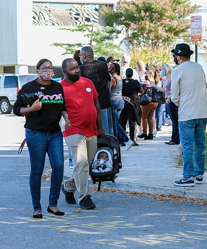 Kindal and George White give their 4-month-old son, Greyson, his first taste of voting as hundreds turned out at the Eastern Henrico Government Center on Nine Mile Road for early, in-person voting on Oct. 24. Lines were common at many early- voting sites throughout Metro Richmond.