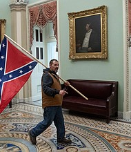 The FBI wants the public's help to identify the man seen in photos, widely circulated online, carrying a large Confederate flag inside the US Capitol on Jan.6.
Credit:	Saul Loeb/AFP/Getty Images