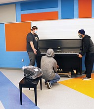 The piano was placed in the music room of the new school, where students will be able to enjoy it once in-person learning resumes.