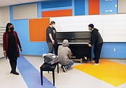 The piano was placed in the music room of the new school, where students will be able to enjoy it once in-person learning resumes.