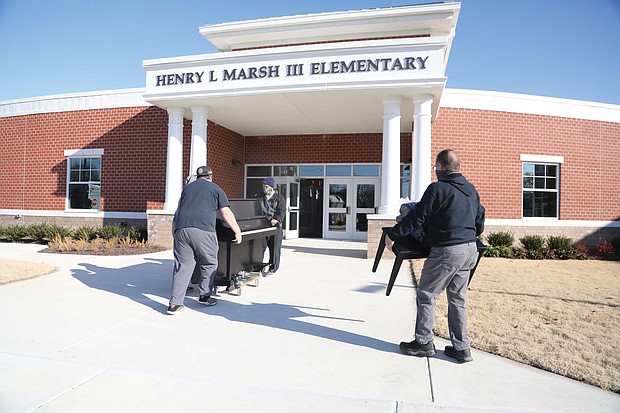 A crew from Famous Jerry Piano Moving in Disputanta moves a new Yamaha piano into Henry L. Marsh III Elementary School on Tuesday under the watchful and excited guidance of Principal Kimberly Cook.