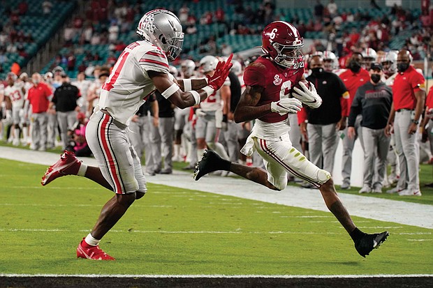 Alabama wide receiver and Heisman Trophy winner DeVonta Smith, right, runs past Ohio State University safety Josh Proctor to score a touchdown during the first half of the NCAA College Football Playoff National Championship on Monday night in Miami.