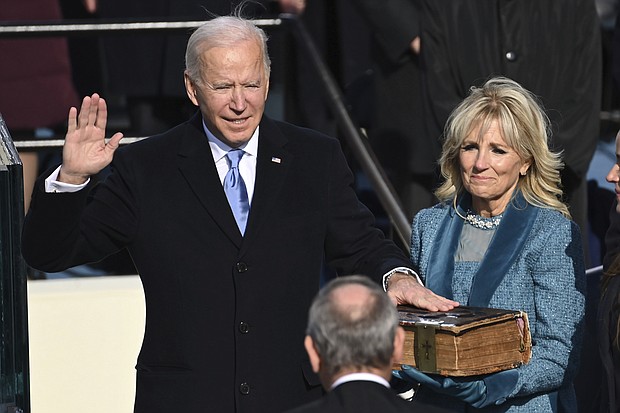 Joe Biden is sworn in as the 46th president of the United States by Chief Justice John Roberts as Jill Biden holds the Bible during the 59th Presidential Inauguration at the US Capitol in Washington, DC, on January 20.
Credit:	Saul Loeb/AP