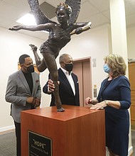 Dr. Derik E. Jones, left, and Dr. Dwight C. Jones, pastors of First Baptist Church of South Richmond, get a closer look at the new bronze sculpture “Hope Empowered by the Truth” with its creator, local artist Kathleen Lowry. The 150-pound sculpture was unveiled at the Decatur Street church on Monday, the Martin Luther King Jr. Holiday, during a ceremony viewed online by more than 200 people. Ms. Lowry donated the piece to the church after attending the socially distanced kickoff last September of First Baptist’s yearlong 200th anniversary celebration. She said the church seemed like the perfect home for the sculpture. “It is recognition of the work you do every day to promote peace in our country,” she said during Monday’s event. “Martin Luther King knew what would be necessary — faith, hopefulness, truth-telling, courage, resilience, kindness and forgiveness. And that is what you are doing and being in the struggle for equality and peace. It is an extremely tall order.” Members of the congregation will be able to see the artwork once the church reopens for in-person worship service. The church has held virtual services because of the pandemic.