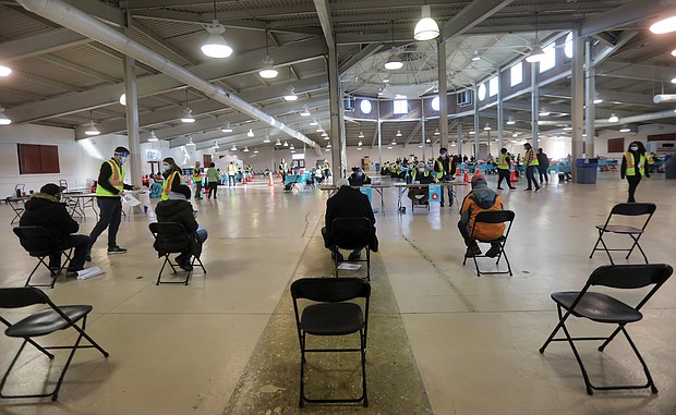 The cavernous Old Dominion Building at Richmond Raceway offers enough space
for vaccination stations to be socially distanced and for people to wait safely for 15 minutes after being inoculated to ensure they do not have an adverse reaction. More than 1,000 people were inoculated against COVID-19 there on Tuesday.