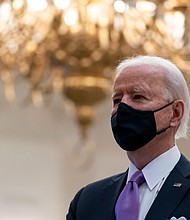 President Joe Biden stands during a performance of the national anthem, during a virtual Presidential Inaugural Prayer Service in the State Dinning Room of the White House on January 21, in Washington, DC.
Credit:	Alex Brandon/AP
