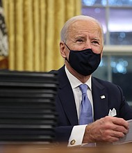 President Joe Biden prepares to sign a series of executive orders at the Resolute Desk in the Oval Office just hours after his inauguration on January 20 in Washington, DC.
Credit:	Chip Somodevilla/Getty Images