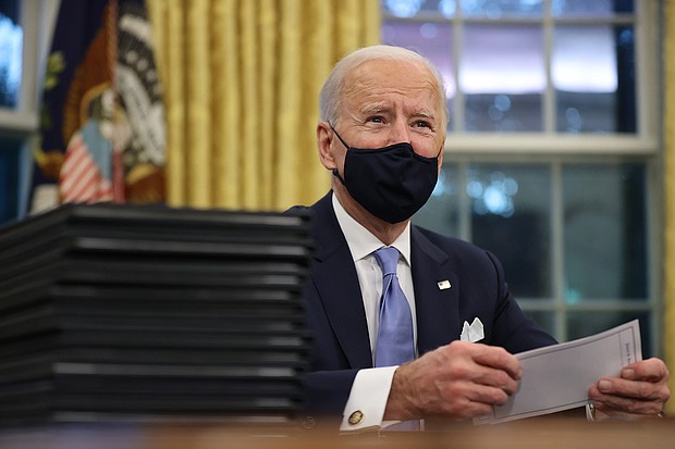 President Joe Biden prepares to sign a series of executive orders at the Resolute Desk in the Oval Office just hours after his inauguration on January 20 in Washington, DC.
Credit:	Chip Somodevilla/Getty Images