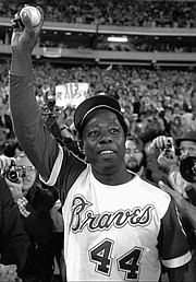 Atlanta Braves' Hank Aaron holds aloft the ball he hit for his 715th career home run in this April 8, 1974 photo from Atlanta.   (AP photo)