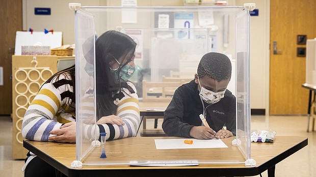 Pre-kindergarten teacher Sarah McCarthy works with a student at Dawes Elementary in Chicago, Monday, Jan. 11, 2021.
Credit:	Ashlee Rezin Garcia/Chicago Sun-Times/AP