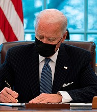 US President Joe Biden signs an Executive Order reversing  Trump era ban on Transgender serving in the military while in the Oval Office of the White House in Washington, DC, on January 25, 2021.
Credit:	Jim Watson/AFP/Getty Images