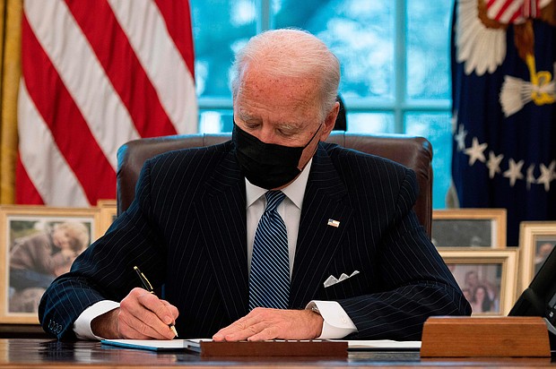 US President Joe Biden signs an Executive Order reversing  Trump era ban on Transgender serving in the military while in the Oval Office of the White House in Washington, DC, on January 25, 2021.
Credit:	Jim Watson/AFP/Getty Images