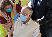McKinley Woodson, 93, gets vaccinated by Kathleen Sardegna at the mass vaccination effort Saturday at Richmond Raceway. Son Kelvin Woodson helped his dad and his 80-year-old mother, Bernice Woodson, navigate the process.