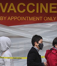 People with appointments stand in line to receive the COVID-19 vaccine at a vaccination site at Lincoln Park in East Los Angeles amid eased lockdown restrictions on January 28, 2021 in Los Angeles, California.
Credit:	Mario Tama/Getty Images