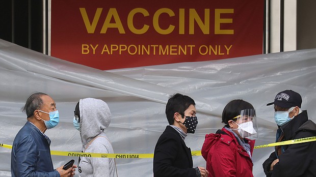 People with appointments stand in line to receive the COVID-19 vaccine at a vaccination site at Lincoln Park in East Los Angeles amid eased lockdown restrictions on January 28, 2021 in Los Angeles, California.
Credit:	Mario Tama/Getty Images