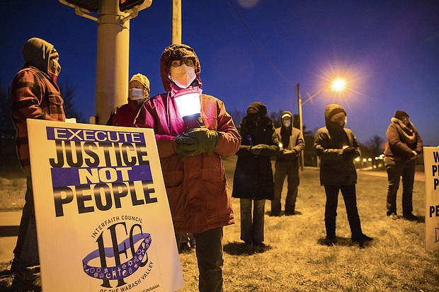 Bloomington anti-death-penalty activist Glenda Breeden holds a lamp while protesting against the execution of Lisa Montgomery and two others.
Credit:	Jeremy Hogan/SOPA Images/SIPAPRE/Sipa USA/AP