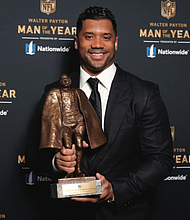 Seattle Seahawks quarterback Russell Wilson shows off his trophy after winning the Walter Payton NFL Man of the Year Award last weekend during the NFL Honors ceremony as part of Super Bowl LV.