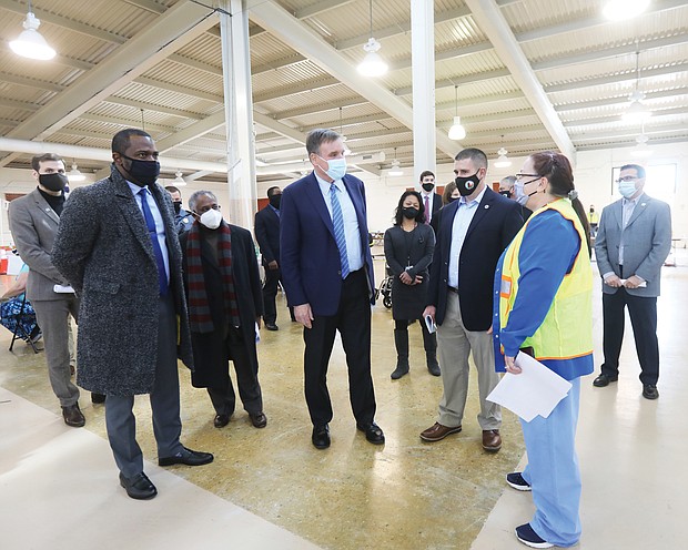 U.S. Sen. Mark R. Warner, center, thanks registered nurse Robin Gilbert of Henrico Health Services, who was overseeing nurses administering COVID-19 vaccinations Wednesday at the Richmond Raceway in Henrico County. Sen. Warner was joined on a tour of the inoculation site by, from left, Richmond Mayor Levar M. Stoney, Henrico’s Fairfield District Supervisor Frank J. Thornton and tour guide, Jackson Baynard, Henrico County’s chief of emergency management.