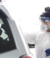 Vanessa Garnes administers a Covid-19 test in Columbus, Ohio on February 21. A new ensemble forecast published Wednesday by the Centers for Disease Control and Prevention suggests the daily Covid-19 death rate will slow in the coming weeks.
Credit:	Robin Chan/Wicked Local Staff Photo/USA Today Network