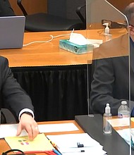 Defense attorney Eric Nelson pictured with former police officer Derek Chauvin listen in court during jury selection on March 10, as Hennepin County court will decide on 14 jurors in Minneapolis.
Credit:	Court TV via AP