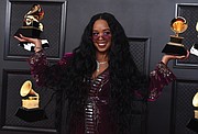 H.E.R. poses in the press room with the award for song of the year for “I Can’t Breathe” and best R&B song.