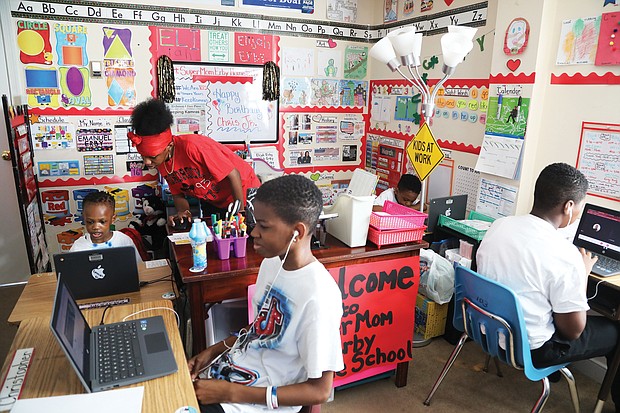 Tisha Erby keeps things moving and the learning going for her four school-age sons in their family’s home. The living room has been turned into a vibrant classroom, with desks and laptops for each of the boys. They are, from left, Emanuel, 3, a pre-schooler at Summer Hill Elementary; Christopher Jr., 13, a seventh-grader at River City Middle School; Elijah, 5, a kindergartner at J.L. Francis Elementary; and Lamar, 11, a sixth- grader at River City Middle. Seated in a high chair in the room, but not pictured, is year- old Tristan, who was working on his own activities given to him by his mom.