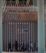 Undocumented immigrants are seen walking along the border wall on March 17 in Ciudad Juarez, Mexico. US Customs and Border Protection says it is deploying more agents to the US-Mexico border.
Mandatory Credit: John Moore/Getty Images