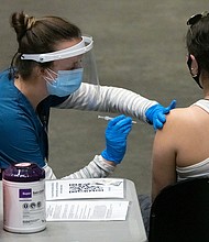 A healthcare worker administers a dose of the Pfizer-BioNTech Covid-19 vaccine at San Diego State University on April 1. Health experts are pleading with Americans to keep taking precautions until they are fully vaccinated.
Mandatory Credit:	 Bing Guan/Bloomberg/Getty Images