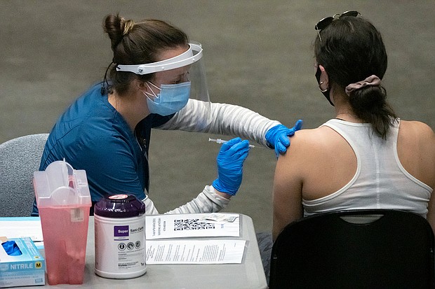 A healthcare worker administers a dose of the Pfizer-BioNTech Covid-19 vaccine at San Diego State University on April 1. Health experts are pleading with Americans to keep taking precautions until they are fully vaccinated.
Mandatory Credit:	 Bing Guan/Bloomberg/Getty Images