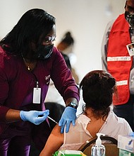 All 50 states have announced when they plan to open up coronavirus vaccinations to everyone eligible. In this March 17, 2021, file photo, health worker administers a dose of a Pfizer COVID-19 vaccine during a vaccination clinic at the Grand Yesha Ballroom in Philadelphia.
Mandatory Credit:	Matt Rourke/AP