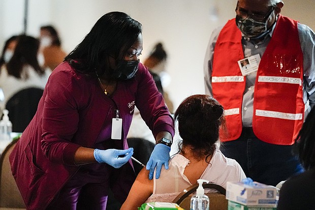 All 50 states have announced when they plan to open up coronavirus vaccinations to everyone eligible. In this March 17, 2021, file photo, health worker administers a dose of a Pfizer COVID-19 vaccine during a vaccination clinic at the Grand Yesha Ballroom in Philadelphia.
Mandatory Credit:	Matt Rourke/AP