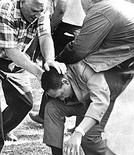 Aides shield the Rev. Martin Luther King Jr. after he was struck by a rock in Marquette Park during an Aug. 5, 1966,
