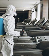A worker in a protective suit cleans exercise equipment. The Centers for Disease Control, on Monday, April 19, 2021, said the risk of surface transmission of Covid-19 is low.
Mandatory Credit:	Shutterstock