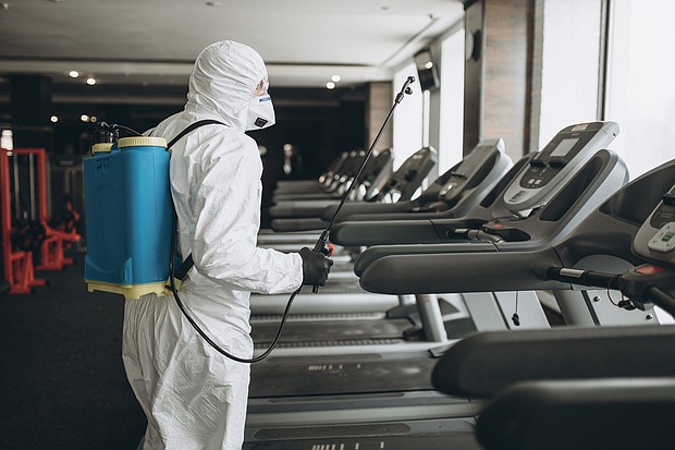 A worker in a protective suit cleans exercise equipment. The Centers for Disease Control, on Monday, April 19, 2021, said the risk of surface transmission of Covid-19 is low.
Mandatory Credit:	Shutterstock