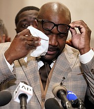 George Floyd’s brother, Philonise Floyd, wipes his eyes during a news conference after the verdict was read Tuesday in Minneapolis in which former police officer Derek Chauvin was convicted of the murder of George Floyd.  Below, Andre Tolleris waves a flag and yells in jubilation to passing motorists Tuesday at Monument and Allen avenues. Many of the drivers and passengers honked their horns in celebration.