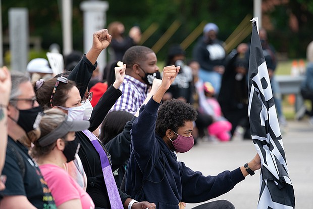 Erving Goldsberry (right) kneels with his fist in the air joining demonstrators blocking bridge traffic during a protest march on April 24 in Elizabeth City, North Carolina. Protestors called for the release of body camera footage from the shooting death of Andrew Brown Jr. on April 21.
Mandatory Credit:	Sean Rayford/Getty Images