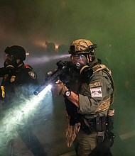 The Biden administration is considering using outside firms to track extremist chatter by Americans online, an effort that would expand the government's ability to gather intelligence but could draw criticism over surveillance of US citizens. Federal officers disperse a crowd during a protest at the Immigration and Customs Enforcement detention facility on September 18, 2020 in Portland, Oregon.
Mandatory Credit:	Nathan Howard/Getty Images