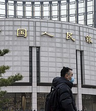 A pedestrian walks past the People's Bank of China (PBOC) building in Beijing, China, on Thursday, March 4.
Mandatory Credit:	Qilai Shen/Bloomberg/Getty Images