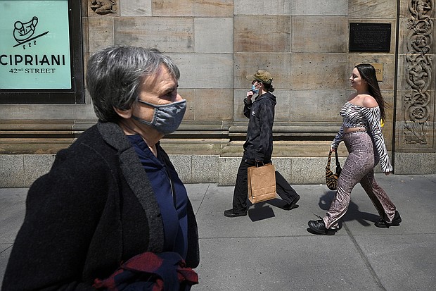 People walk along 42nd Street in New York City on April 27, 2021.
Mandatory Credit:	Anthony Behar/Sipa USA/AP