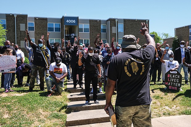 Cruz Sherman, founder of Men in Action, leads a prayer during a rally Saturday of community members and public officials seeking solutions to stop the city’s gun violence. Group members hold up three fingers in tribute to 3-month-old Neziah Hill, who was shot and killed with her 30-year-old mother, Sharnez Hill, on April 27 in the courtyard of the Belt Atlantic Apartments on Midlothian Turnpike. Three others were wounded. The rally was held in view of the apartment complex. Among the officials attending the rally were U.S. Sen. Tim Kaine, state Sen. Joseph D. “Joe” Morrissey, Richmond Police Chief Gerald M. Smith, Henrico Police Chief Eric D. English, Richmond Sheriff Antionette V. Irving, Richmond Commonwealth’s Attorney Colette W. McEachin, Richmond Public Schools Superintendent Jason Kamras and Henrico County Sheriff Alisa Gregory.