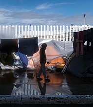 A migrant girl walks at an improvised camp outside El Chaparral crossing port as she and another wait for US authorities to allow them to start their migration process in Tijuana, Baja California state, Mexico, on March 11.
Mandatory Credit:	GUILLERMO ARIAS/AFP/AFP via Getty Images