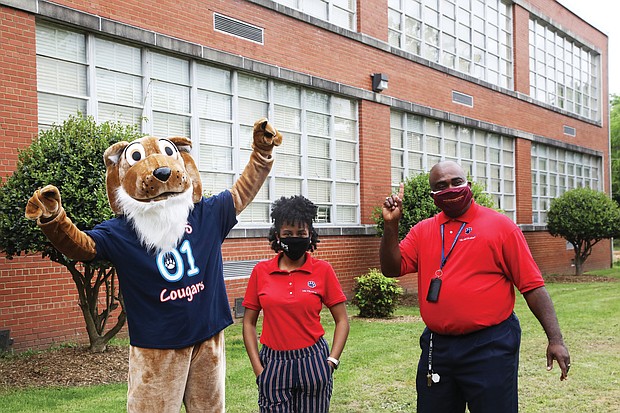 Ashley Bland pauses for a photo with John B. Cary’s Principal Michael Powell and the school mascot following the announcement.