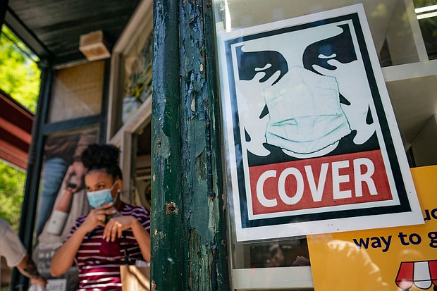 New York will adopt the US Centers for Disease Control and Prevention's guidelines to not require masks or social distancing for vaccinated people beginning Wednesday. A customer exits a corner market while wearing a protective mask in the retail shopping district of the SoHo neighborhood of the Manhattan borough of New York, Friday, May 14, 2021.
Mandatory Credit: John Minchillo/AP