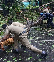 Police clear fallen trees from a road following heavy rains and strong winds brought by Cyclone Tauktae, at Panjim, Goa on May 16.
Mandatory Credit:	Umesh Zarmekar/AFP/Getty Images