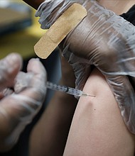 Nearly all states require some form of parental or guardian consent for vaccine providers to administer Covid-19 shots to people ages 12 to 15, a CNN analysis finds. But there are a few exceptions. A teenager is shown being inoculated with Pfizer's vaccine against coronavirus disease (COVID-19) after Georgia authorized the vaccine for ages over 12 years, at Dekalb Pediatric Center in Decatur, Georgia, U.S. May 11, 2021.
Mandatory Credit:	Chris Aluka Berry/Reuters