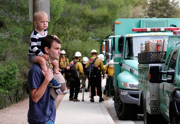 Pacific Palisades resident Mike Sutton, 31, and his son, Tommy, 2, watch the deployment of firefighters on May 16.
Mandatory Credit:	Ringo H.W. Chiu/AP
