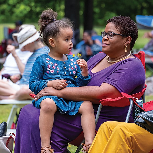 Mommy and me time/Emmie Aslan, 3, sits with her mother, Joli Aslan, while they enjoy the music of the Desiree Roots Jazz Trio at last Saturday’s outdoor concert at The Cultural Arts Center at Glen Allen.