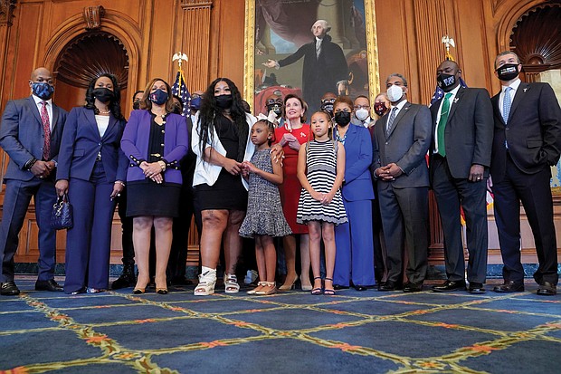 Members of George Floyd’s family and their attorney, Benjamin Crump, right, stand Tuesday in the Rayburn Room of the U.S. Capitol with House Speaker Nancy Pelosi, in red, and Rep. Karen Bass, next to her in blue.